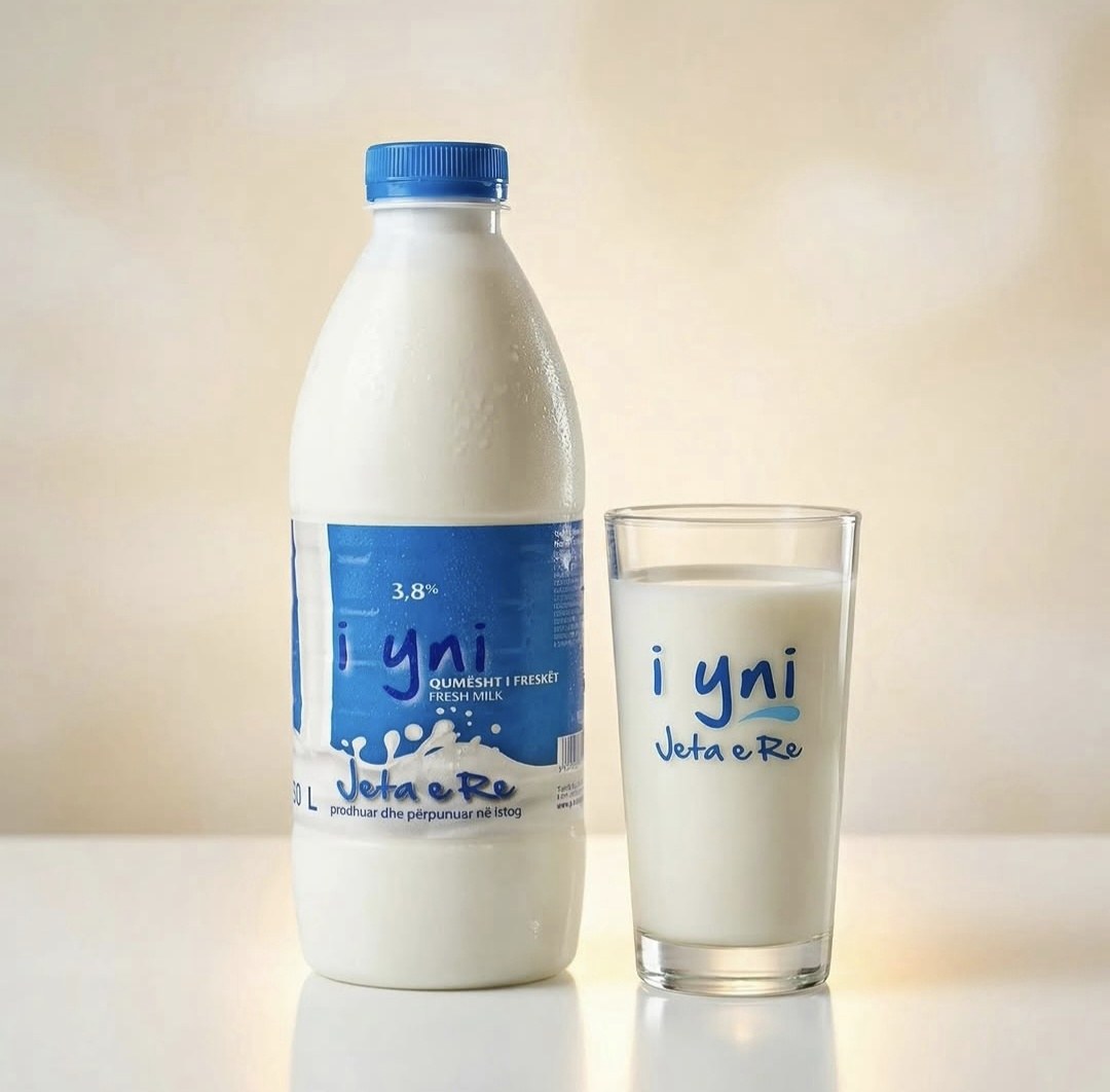 Shishja e qumështit të freskët "i yni" nga Jeta e Re pranë një gote me qumësht